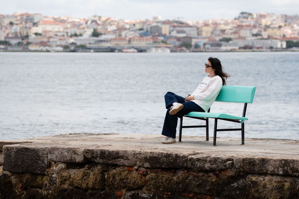 Woman sitting next to a river and thinking about life
