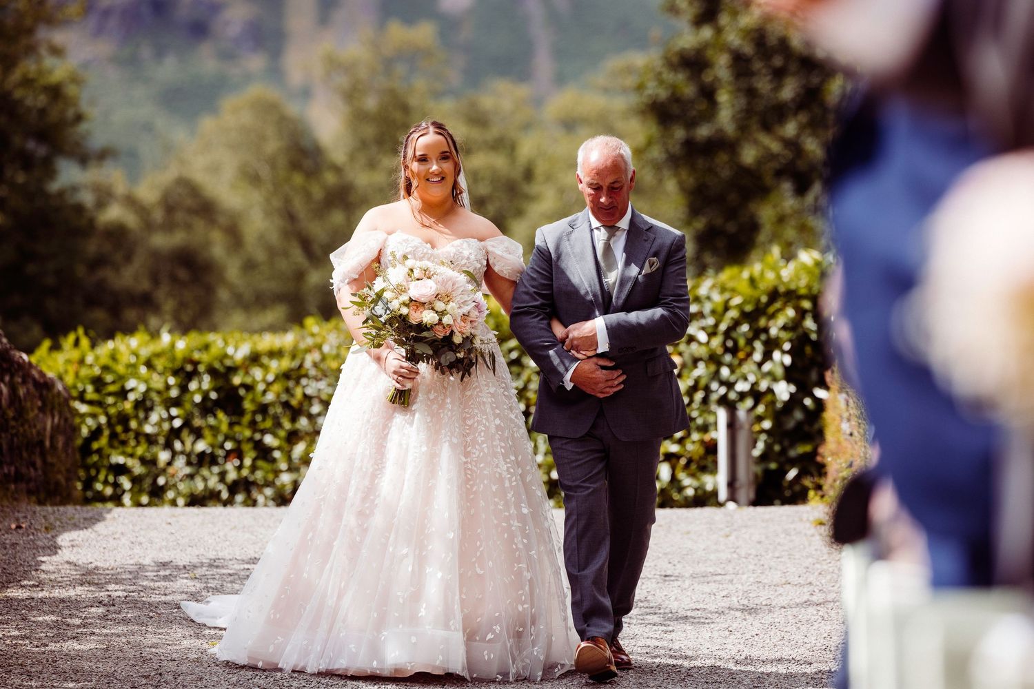 Bride and groom exchange vows outdoors at elegant wedding ceremony with officiant reading from script.