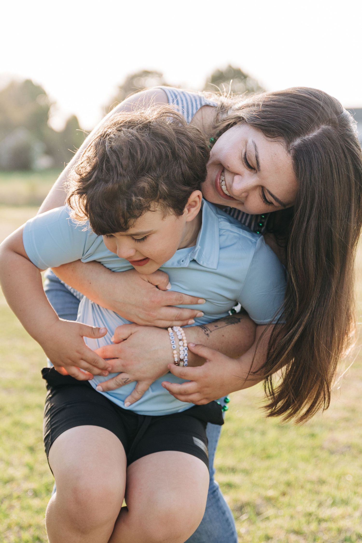 Mom holds her son and smiles wide during Charlotte family photos.