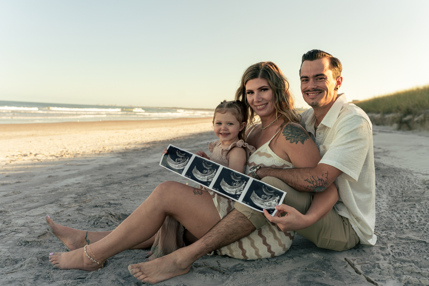 Family baby announcement on the beach