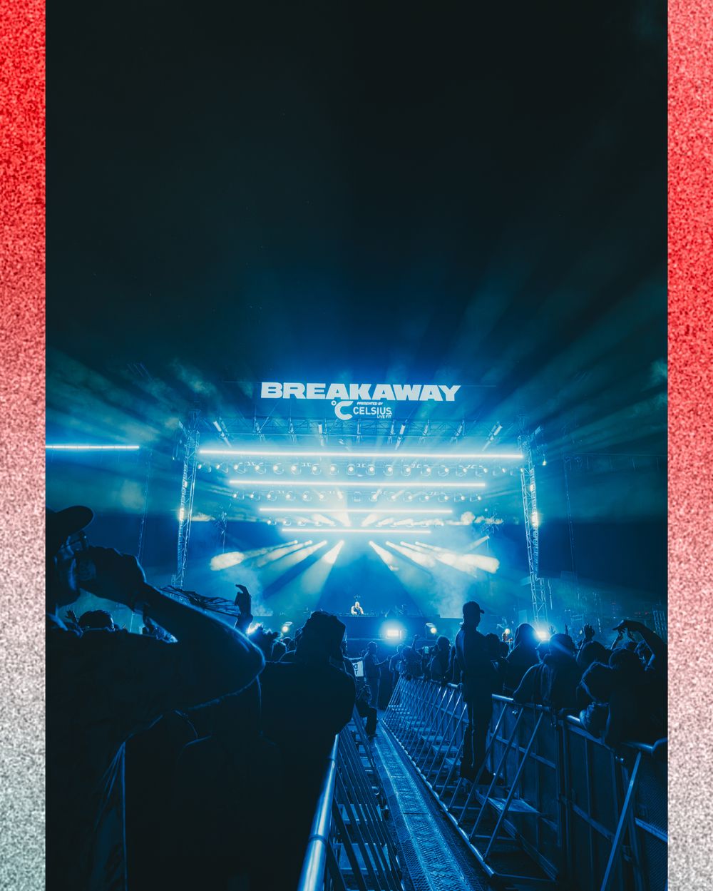 Breakaway music festival stage with vibrant blue light beams illuminating a crowd at night.