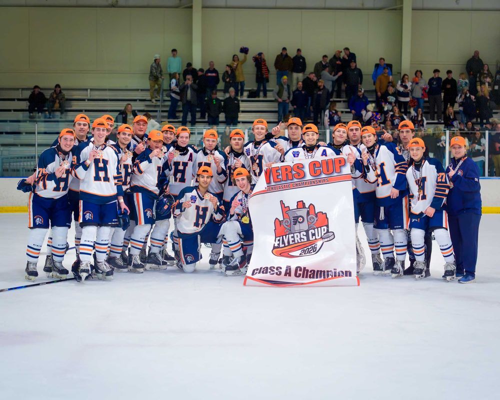 Hershey Trojans line up on ice with Flyers Cup banner, crowd in the stands behind by Deanna Fox, SportsFox Photography based in Hershey PA.