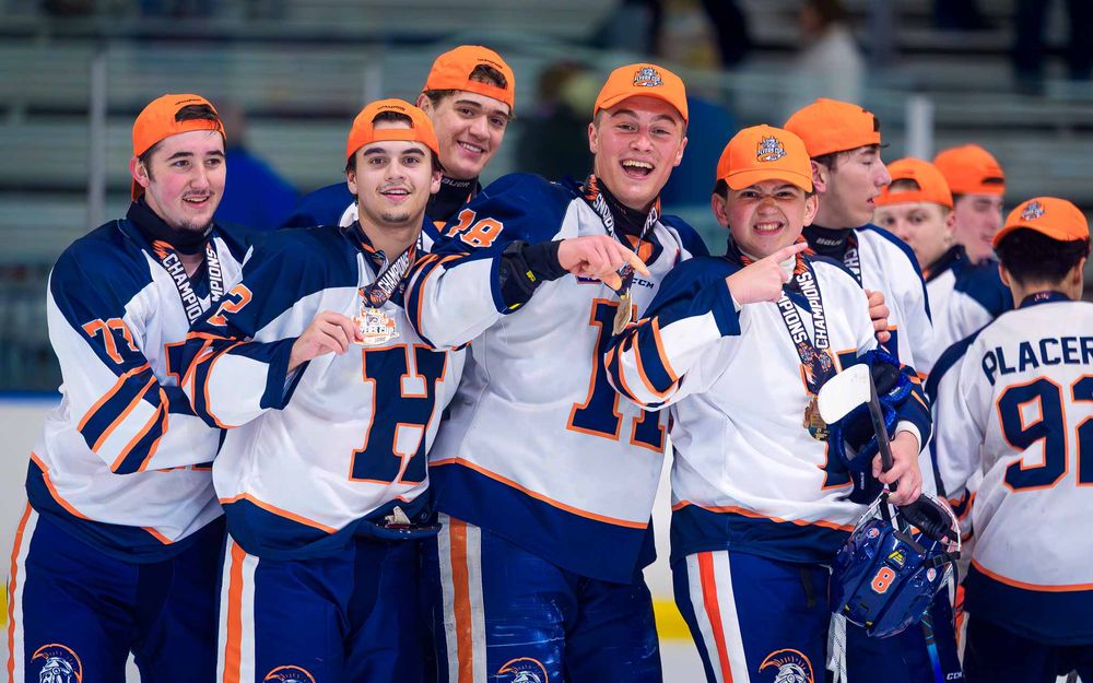 Hershey Trojans celebrate in orange hats after winning the Flyers Cup by Deanna Fox, SportsFox Photography based in Hershey PA.