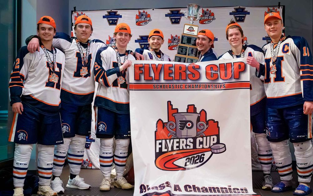 Hershey Trojans pose at the Flyers Cup backdrop as Class A champions by Deanna Fox, SportsFox Photography based in Hershey PA.