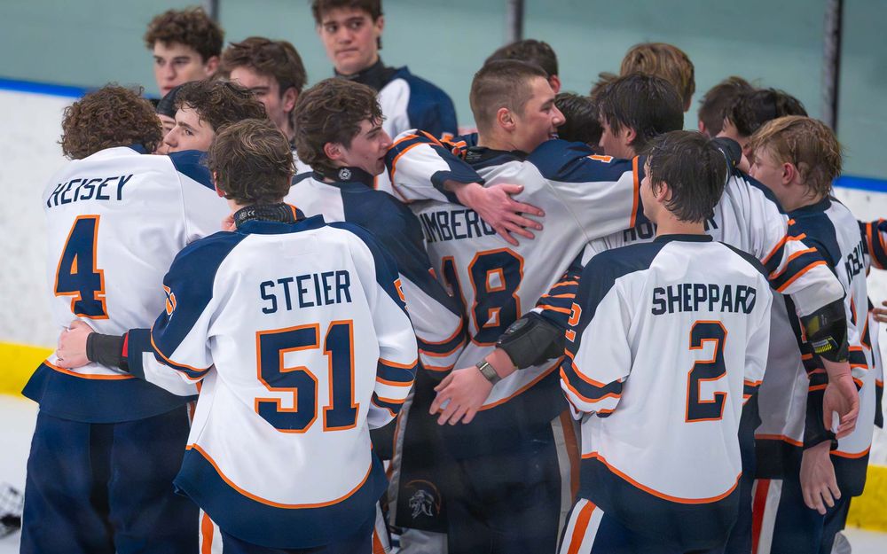 Hershey Trojans huddle on ice, jerseys showing Steier #51 and Sheppard #2 by Deanna Fox, SportsFox Photography based in Hershey PA.