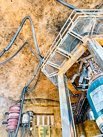 Industrial mechanical theming with pipes and equipment in a themed attraction.