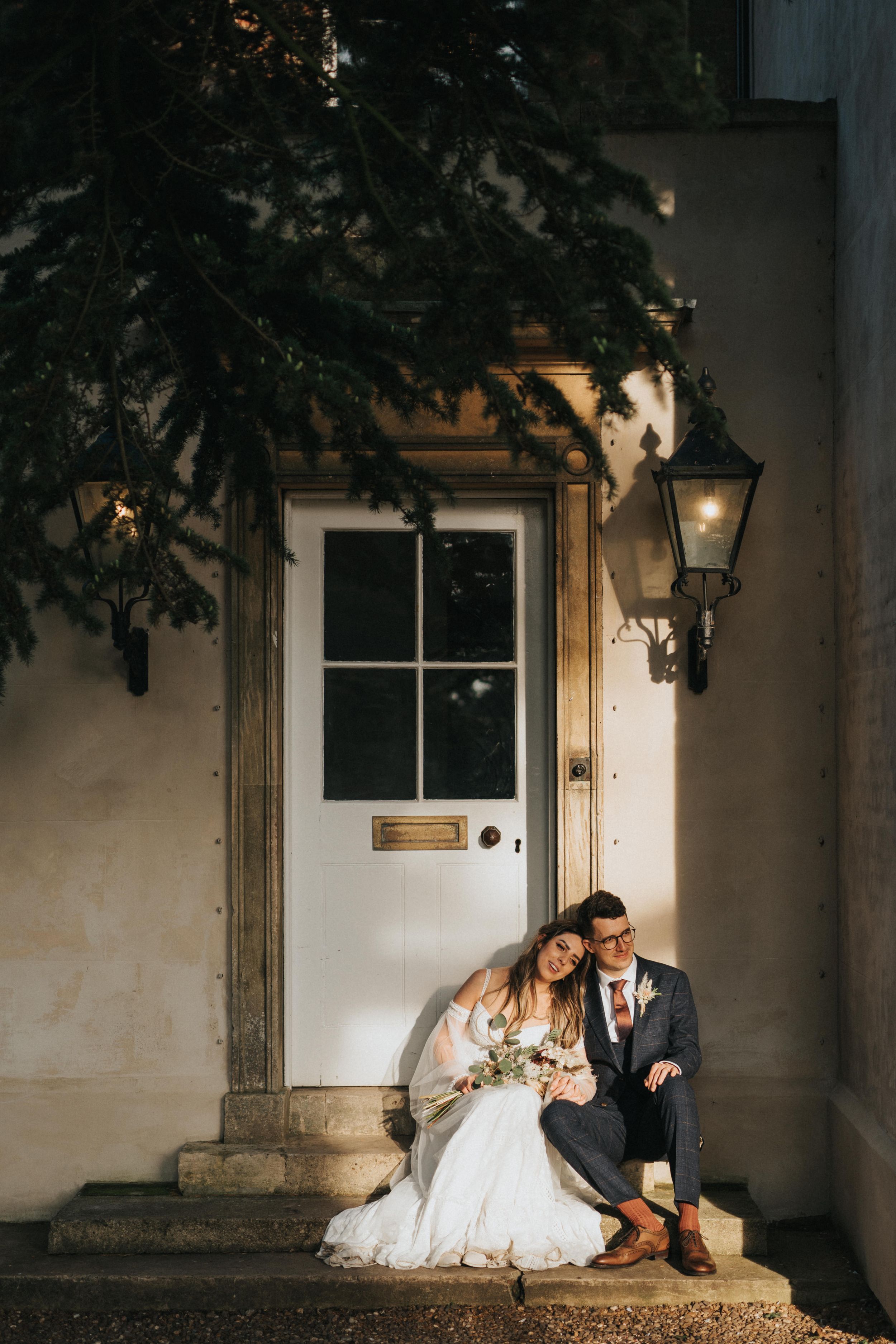 Romantic couple in formal attire share intimate moments against a stone building wall at Aswarby Rectory - taken by Grimsby photographer.