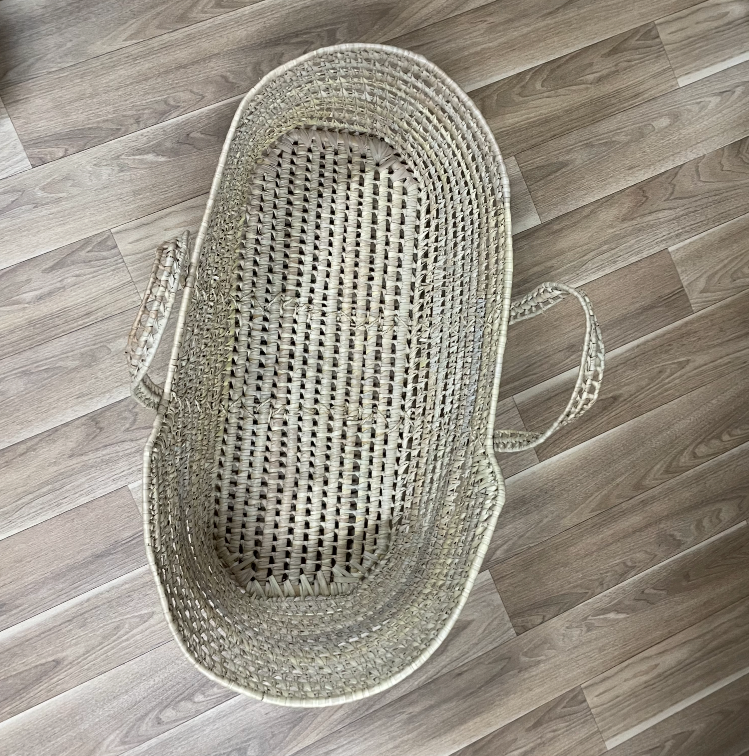 Gray woven basket with handles shown from multiple angles on wooden floor.