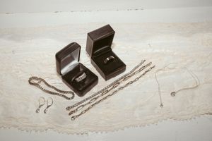 Wedding jewelry and ring boxes arranged on white marble surface for detail shot.