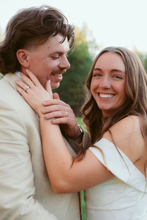 Intimate portrait of newlyweds sharing a tender moment outdoors.