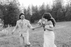 Couple dancing and laughing together in an outdoor field.