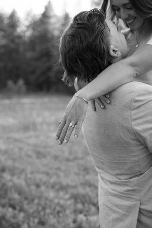 A romantic black and white embrace showing the bride's ring as the couple shares an intimate moment.