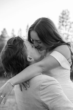 An intimate black and white portrait capturing a joyful embrace between newlyweds.