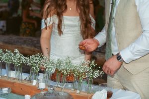 Wedding reception table decorated with delicate baby's breath flowers in small glass vases.