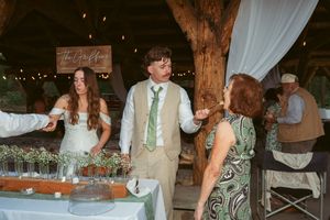 Wedding celebration in a rustic barn venue with string lights and wooden beams.