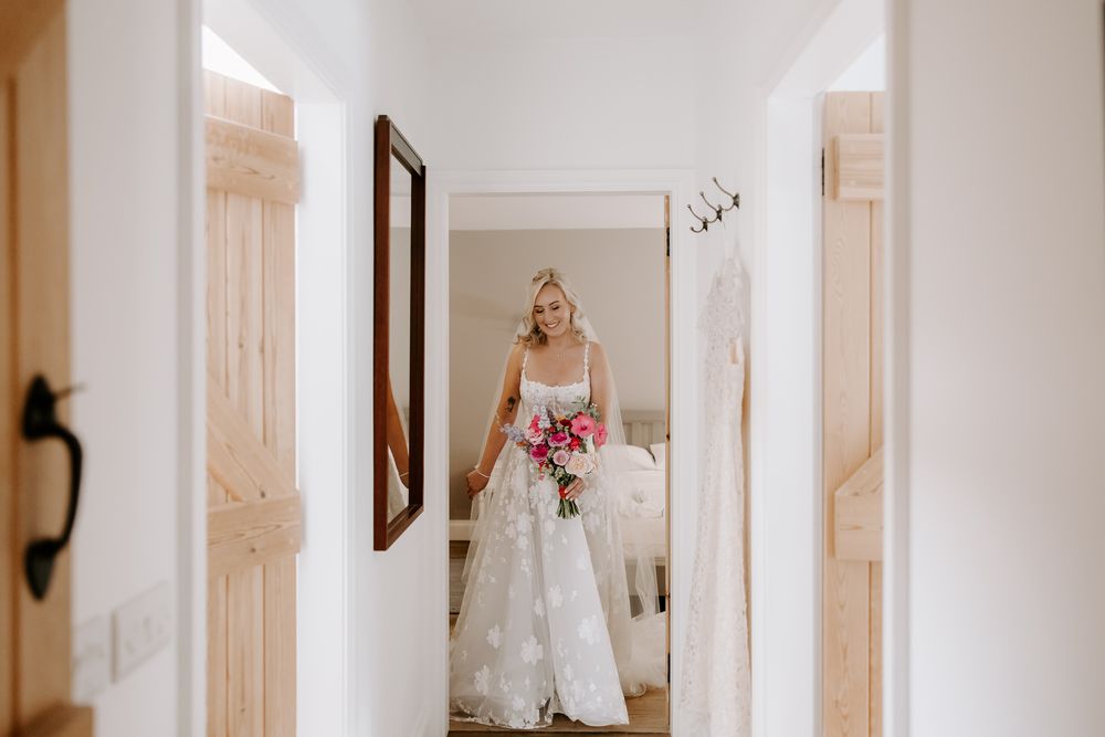 Interior hallway with soft white minimalist decor featuring rustic white doors and natural lighting.