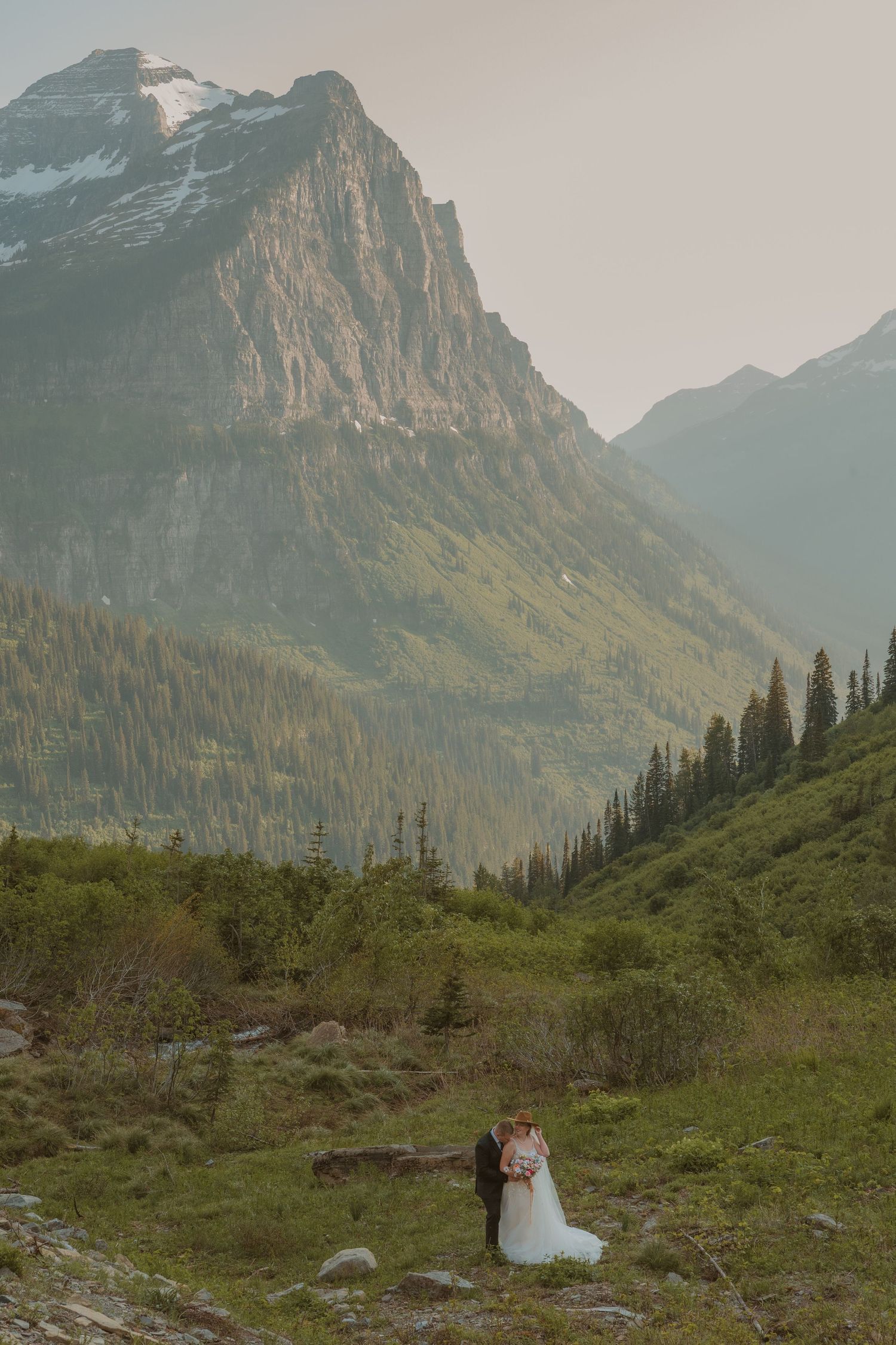 A scenic mountain landscape with evergreen forests in Glacier National Park serves as a majestic backdrop.