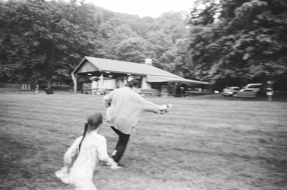 A black and white photo series showing people performing cartwheels and flips on a grassy lawn.