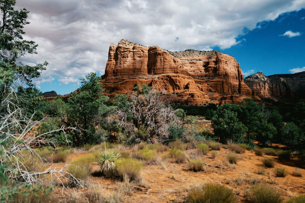 Scenic red sandstone formations and desert landscape under blue skies at Sedona, Arizona on a sunny day.