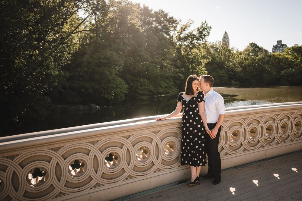 Romantic sunset photoshoot on Bethesda Terrace with ornate stone railings.