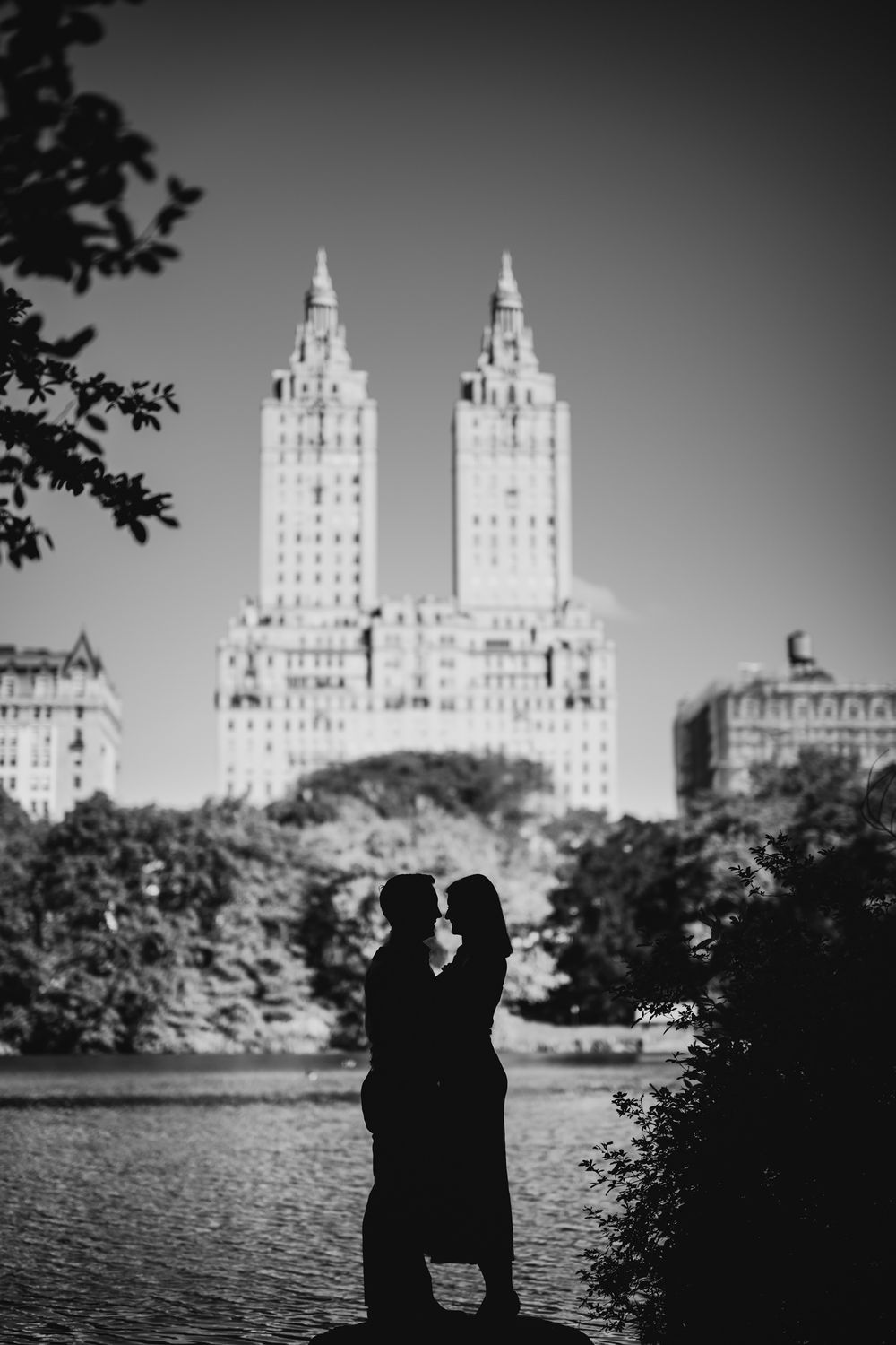 A romantic silhouette of a couple against the iconic San Remo building in Central Park at dusk.