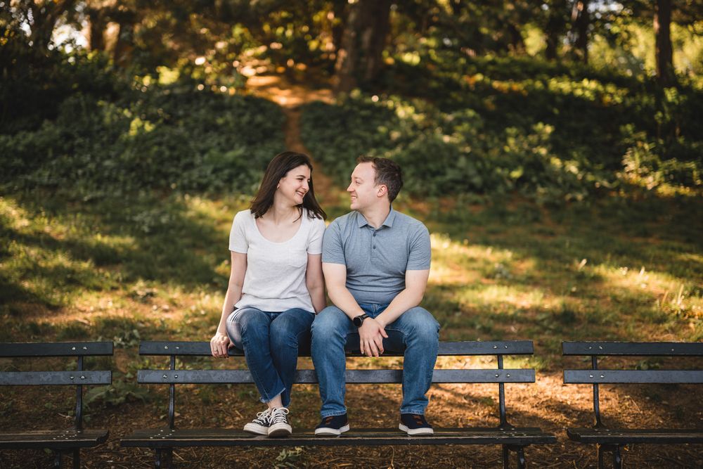 A couple sitting together on a park bench during a sunny afternoon.