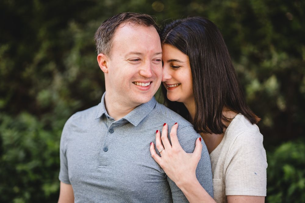 A couple sharing a tender moment while embracing in a garden setting.