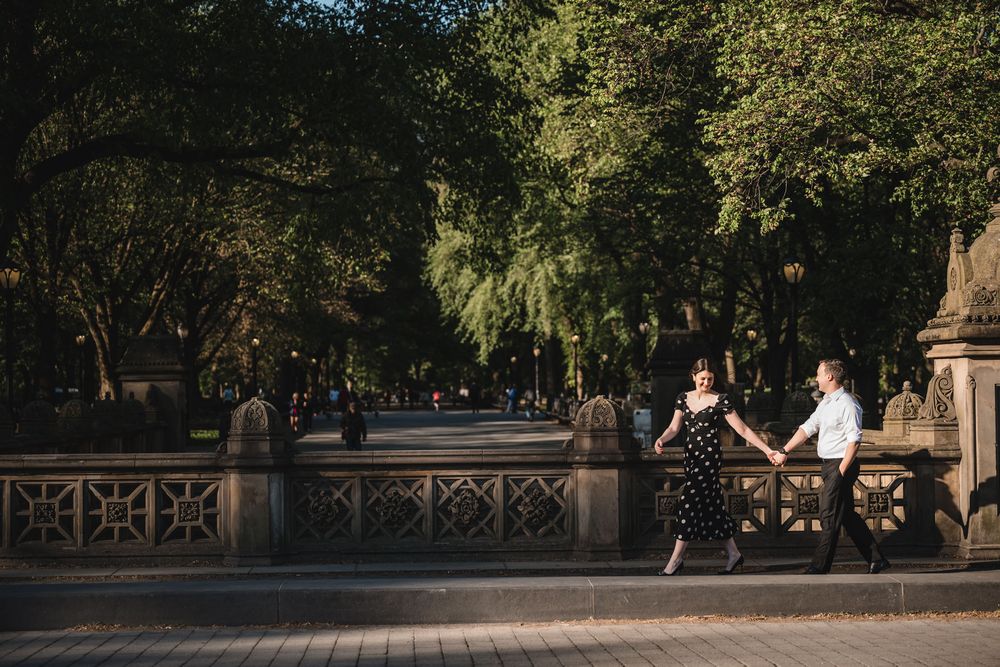 Romantic photoshoot in a tree-lined path with golden sunlight filtering through.