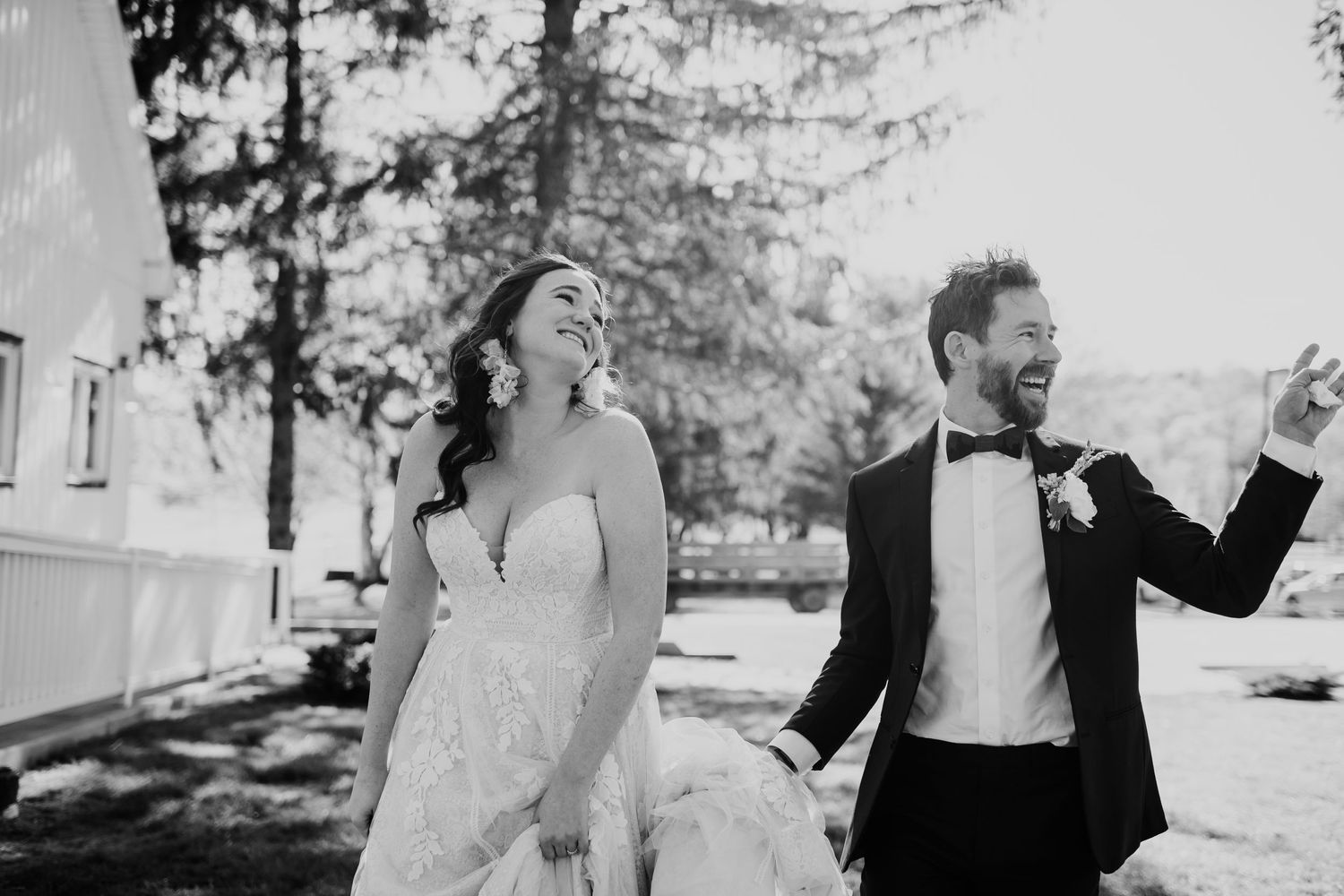 Joyful couple celebrating outdoors in formal wedding attire.
