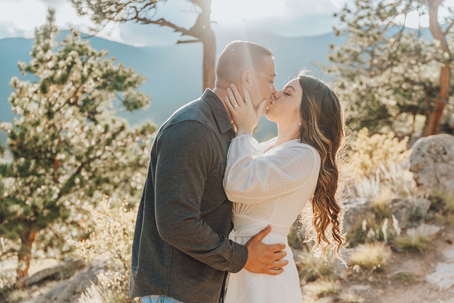 couple standing on rocky ledge at 3M Curve, sweeping mountain views in RMNP, dramatic Colorado elopement backdrop