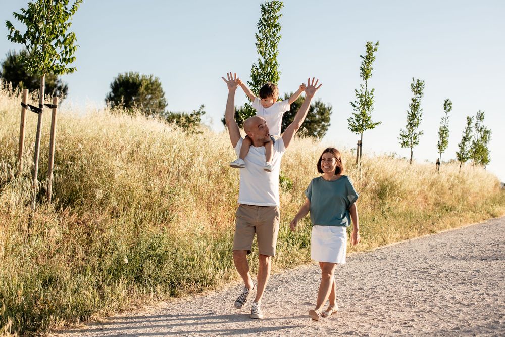 Joyful family moment captured while walking on a rural path surrounded by tall grass.