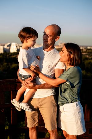 Family sharing a loving moment together against an urban sunset backdrop.