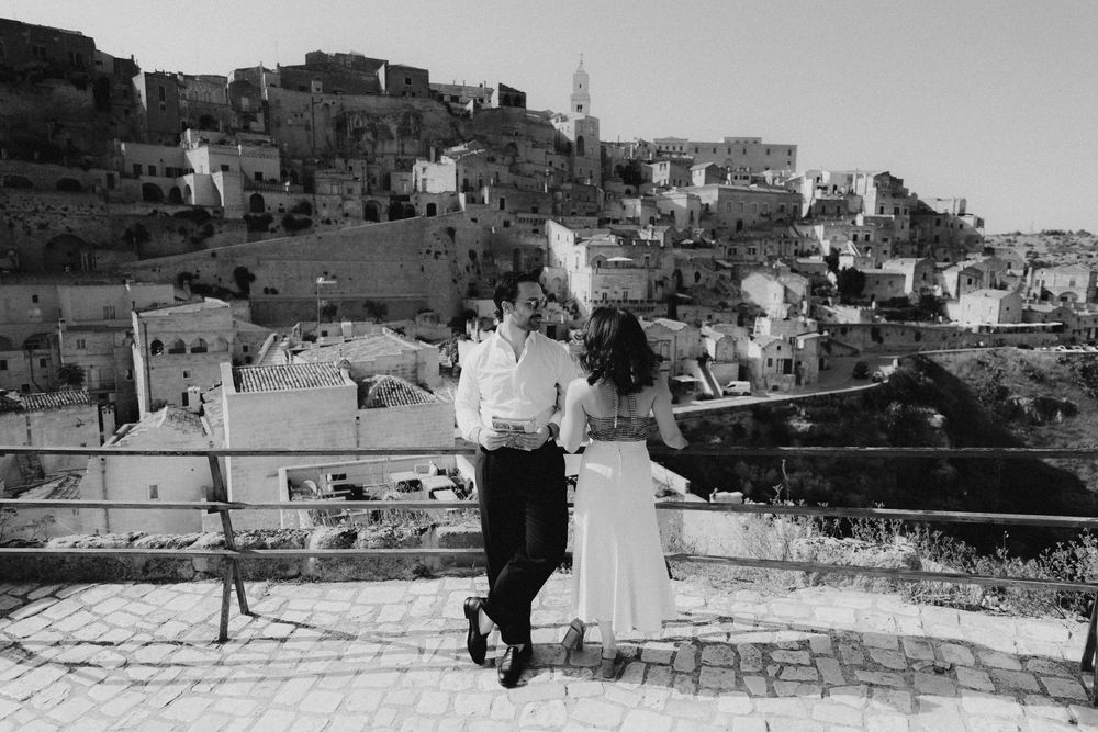 Vintage panoramic black and white view of an old hillside town with stacked buildings and stone architecture.