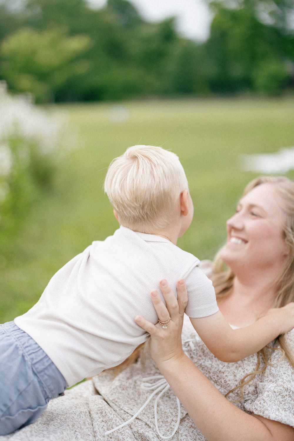 A sequence of four tender moments captured outdoors in natural light showing loving interactions amidst a green background.