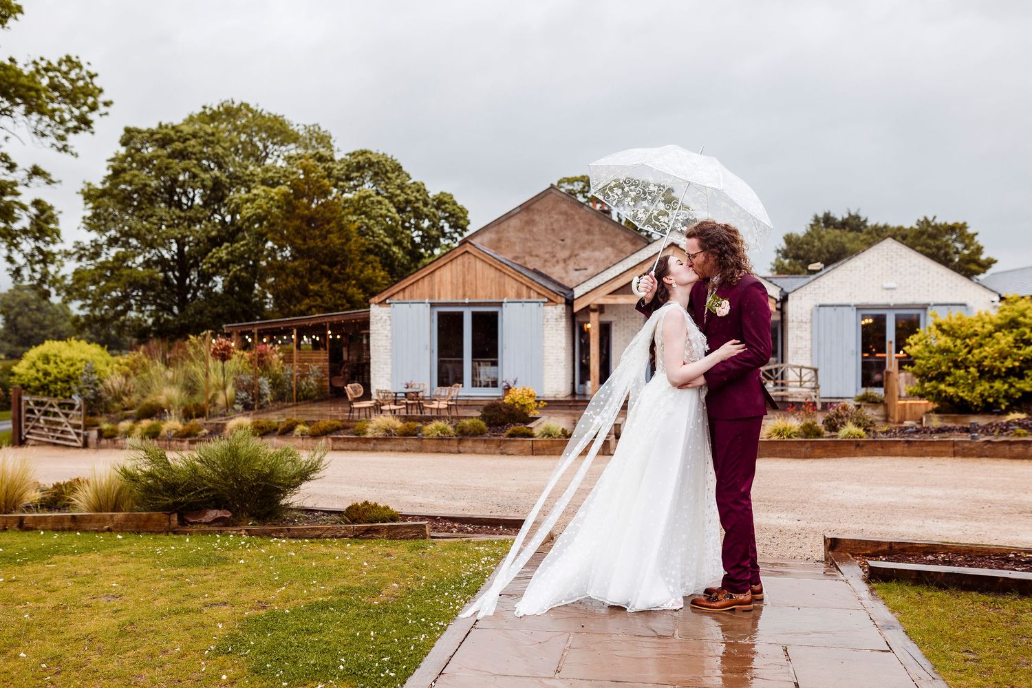 Wedding guests shower a newlywed couple with confetti as they exit their outdoor ceremony venue.