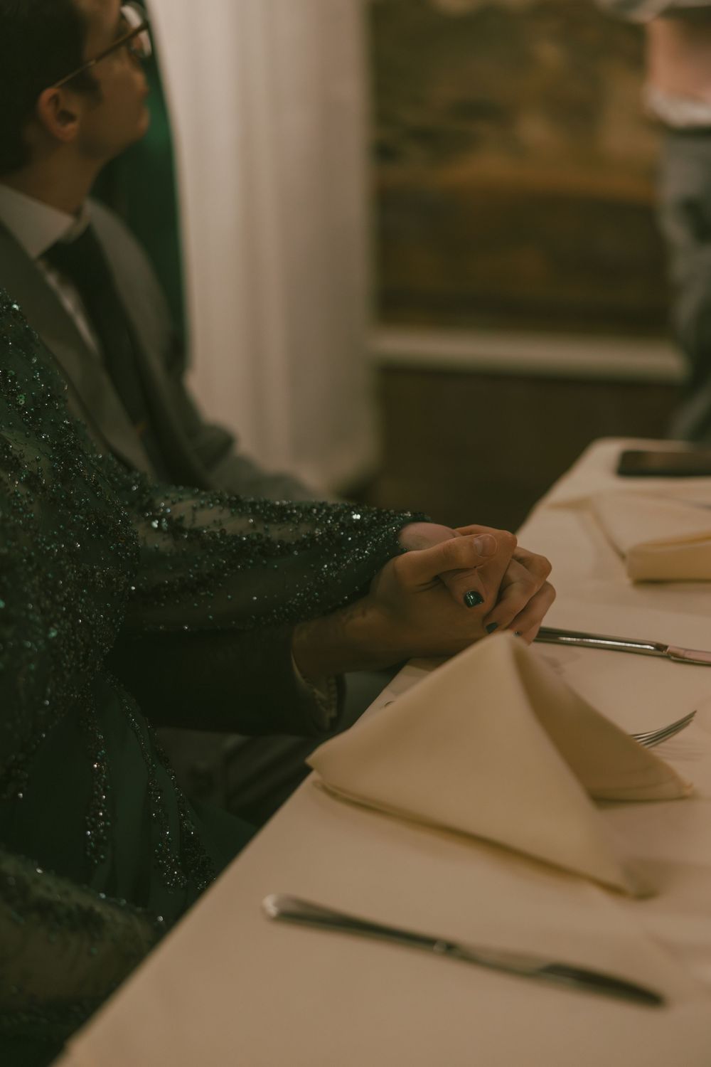 Hands rest on a desk with paperwork in a dimly lit office setting with vintage tones.