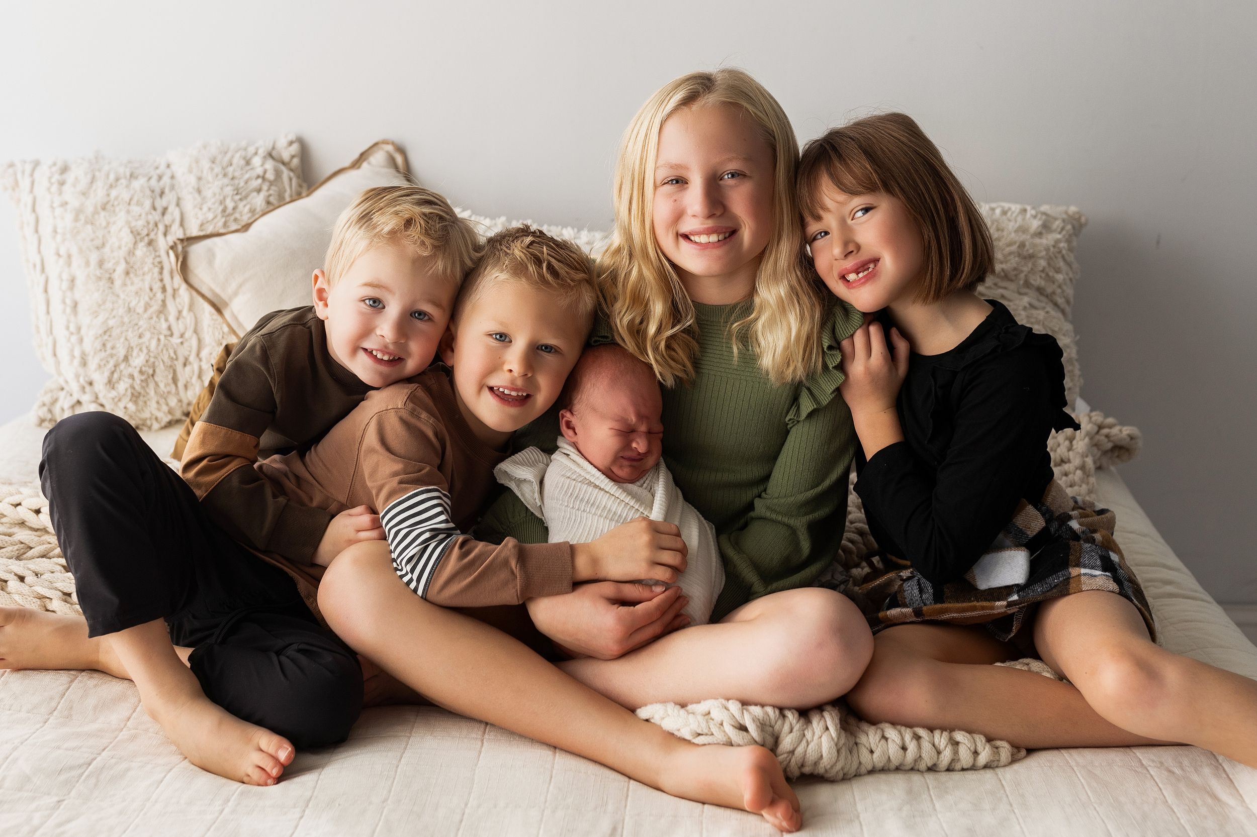 A series of candid family photos showing siblings snuggling and playing together on a couch.