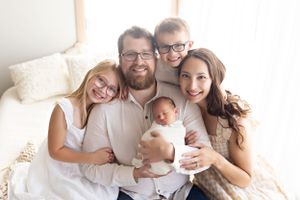 Candid family lifestyle photoshoot in a bright white studio setting.