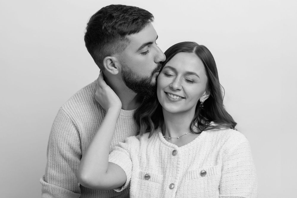 A romantic couple shares tender moments together in black and white photos showing affection and laughter.
