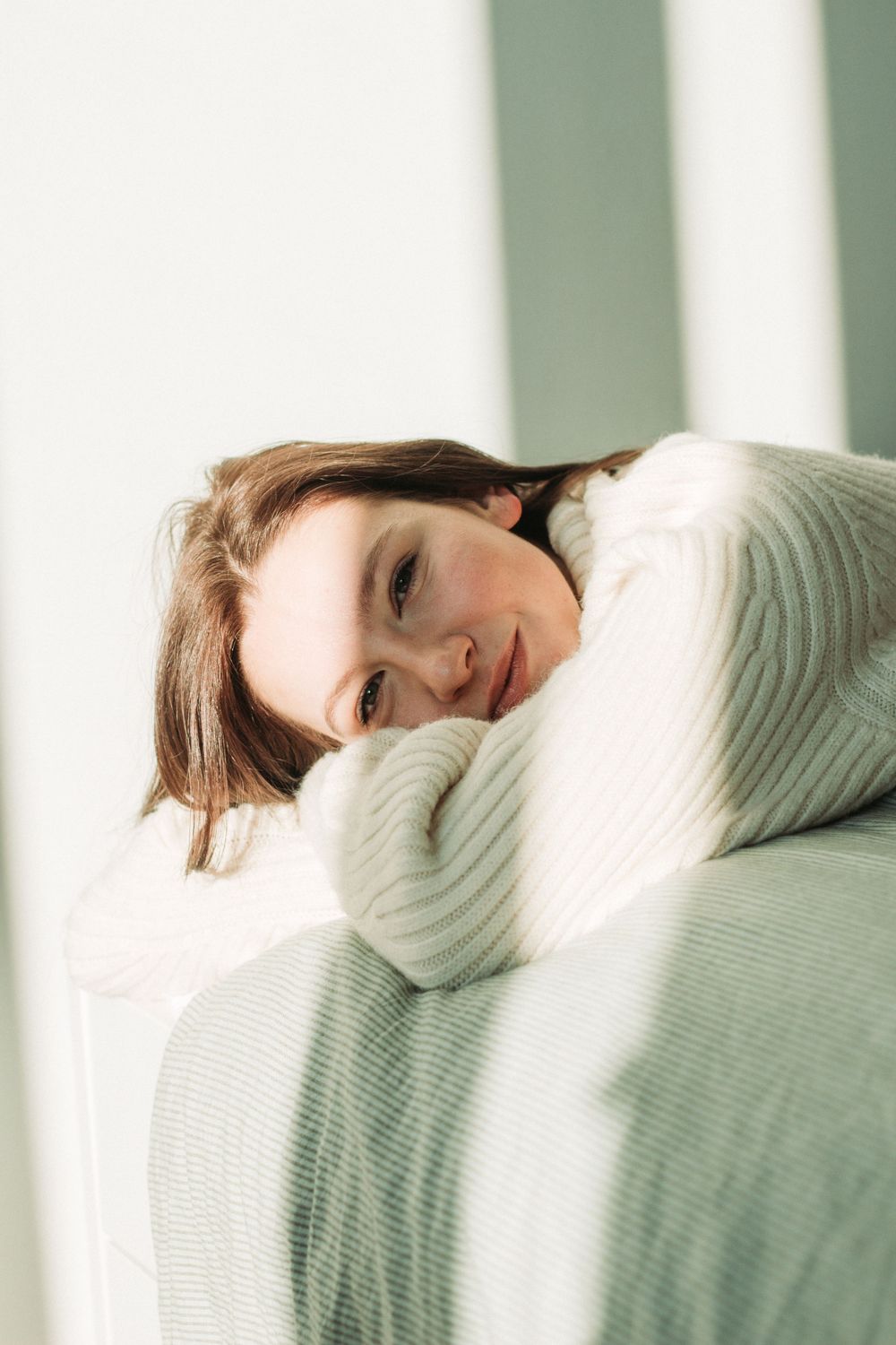 Portrait d'une jeune femme allongée sur un lit à la lumière