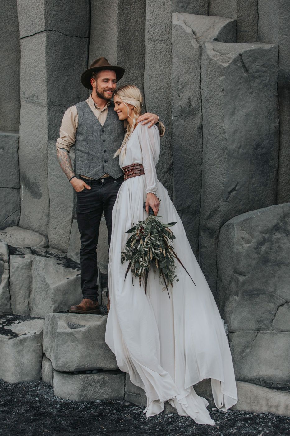 A tender moment between newlyweds against a backdrop of geometric volcanic rock formations.