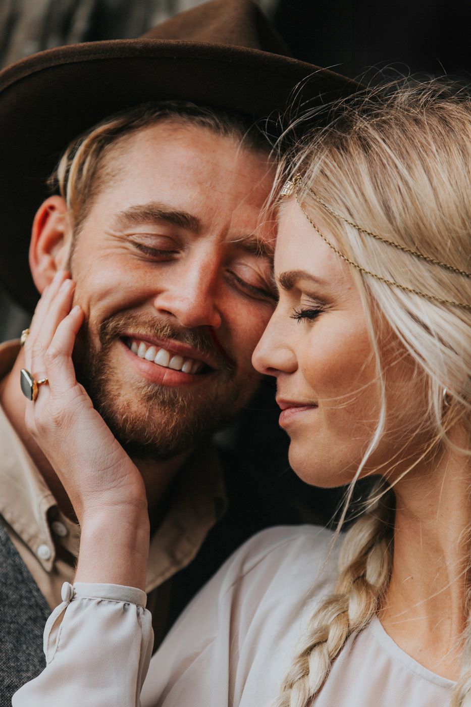 Close-up of tender moment between couple in rustic wedding attire.
