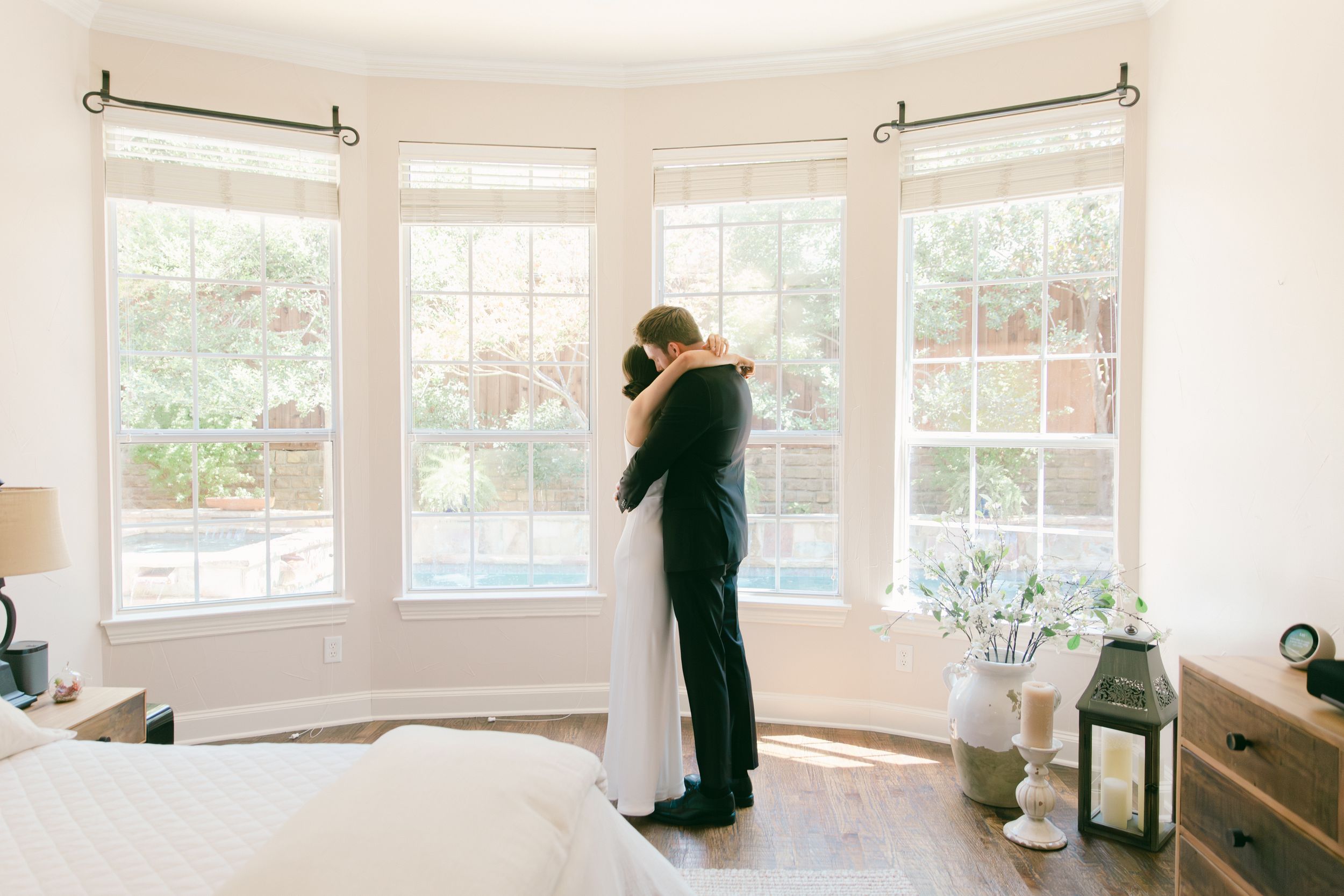 Spacious white wedding venue with large windows and elegant architectural details.