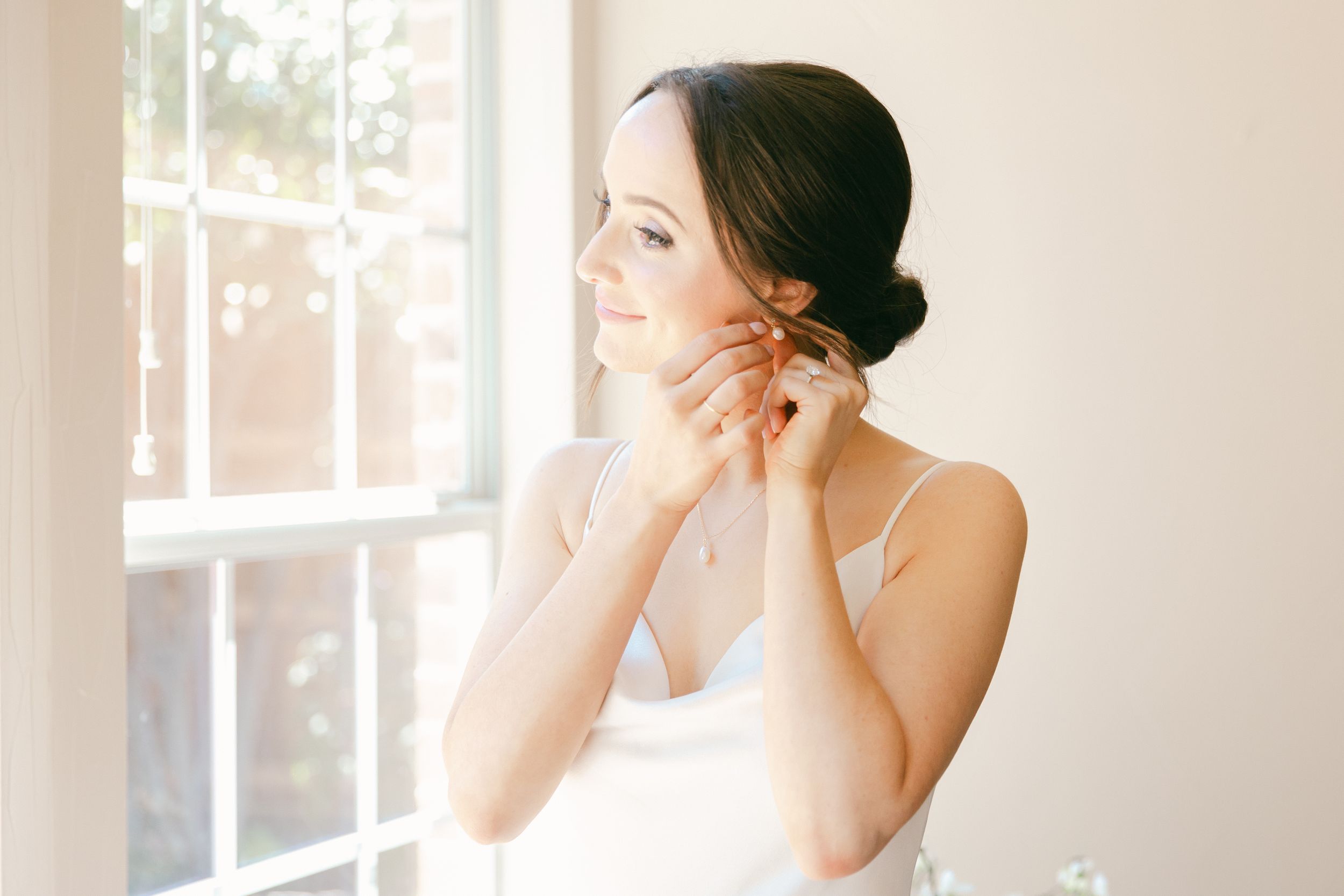 Bright and airy bridal preparation scene with natural window light.