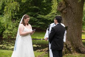 A couple shares an intimate first look moment outdoors before their wedding ceremony in a lush garden setting.