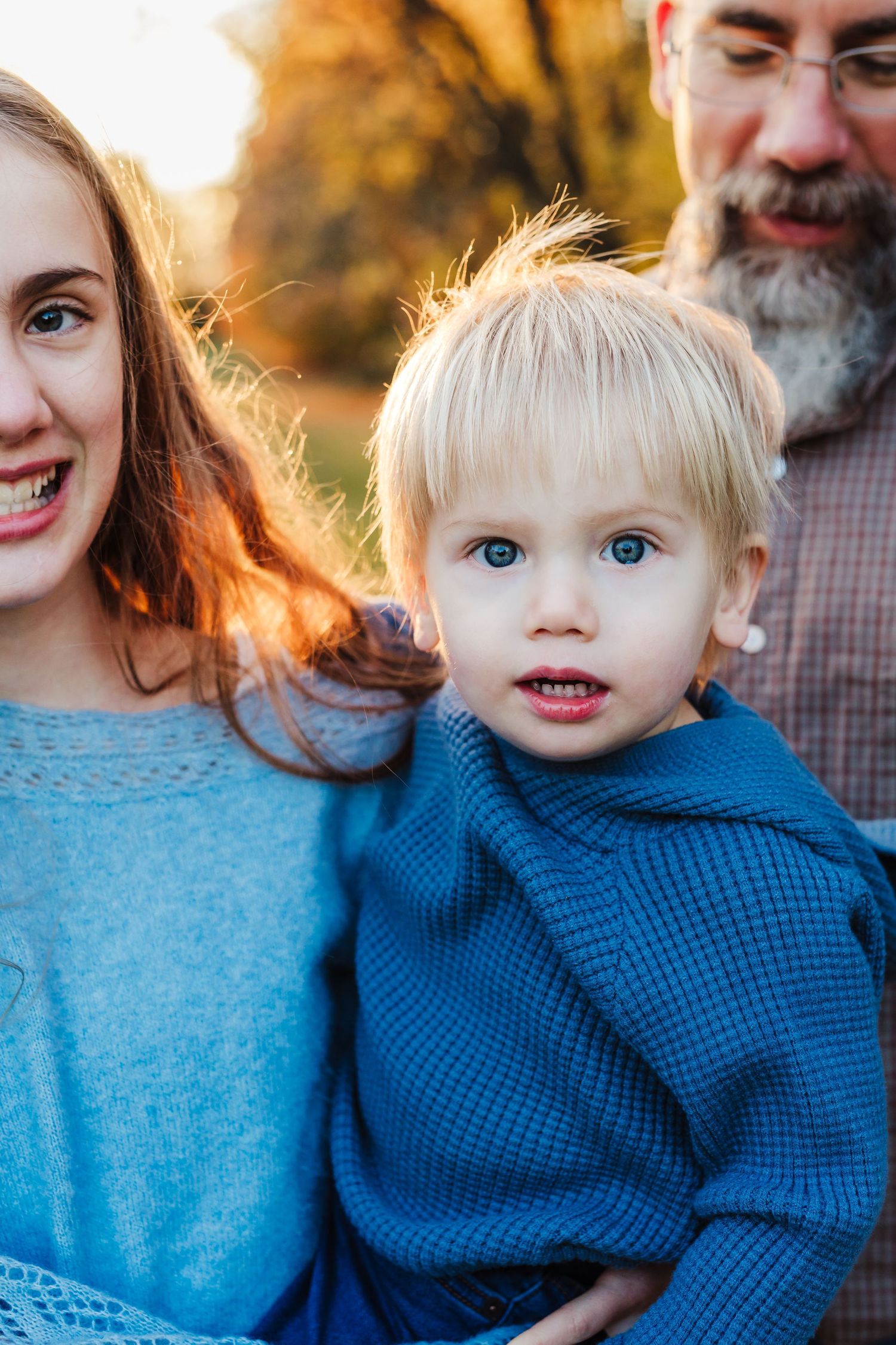 Parent and baby sitting on blanket outdoors sharing a joyful moment together.