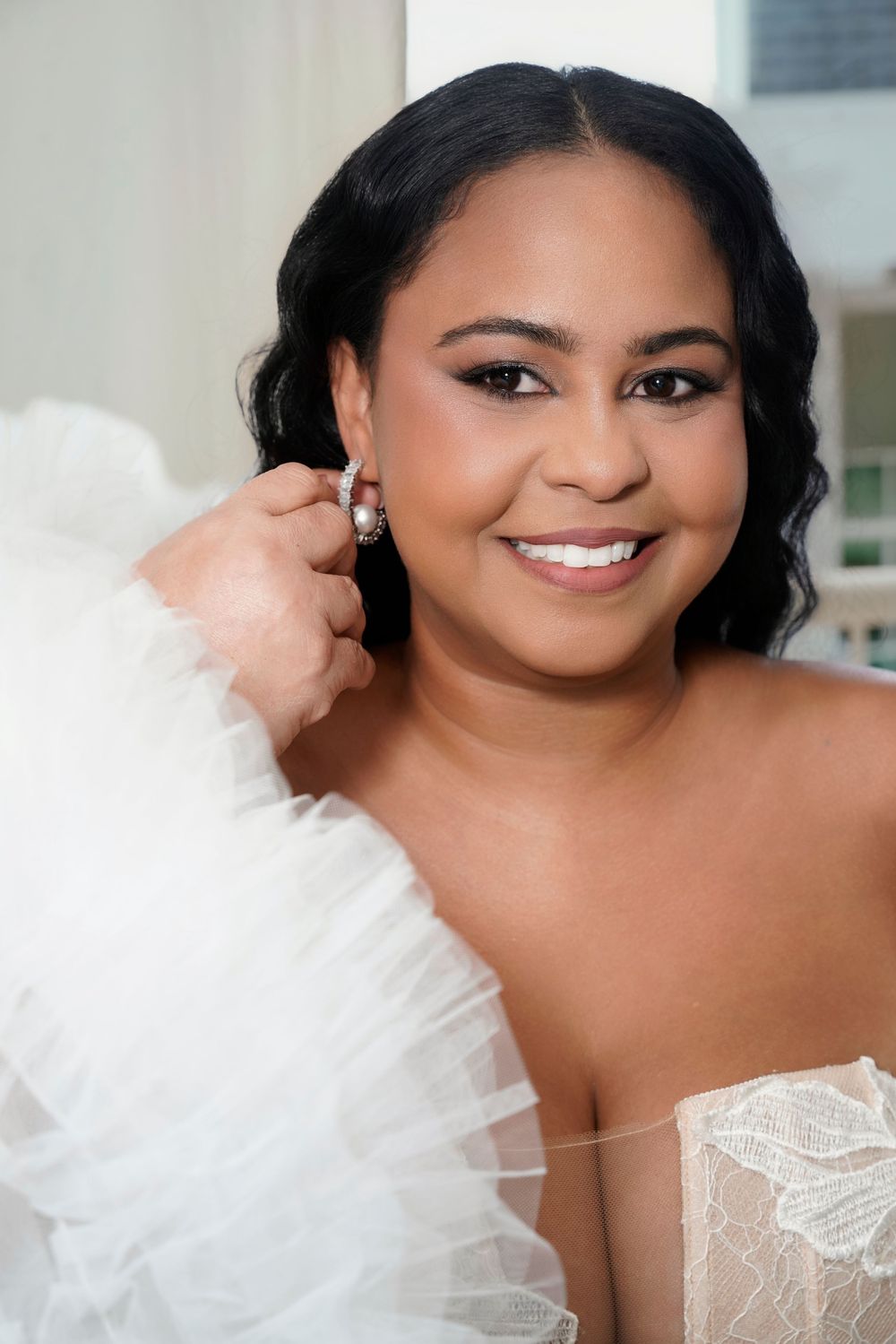 A sequence of closeup photos showing a beautiful bride in a white lace wedding dress with soft glam makeup and dark hair.