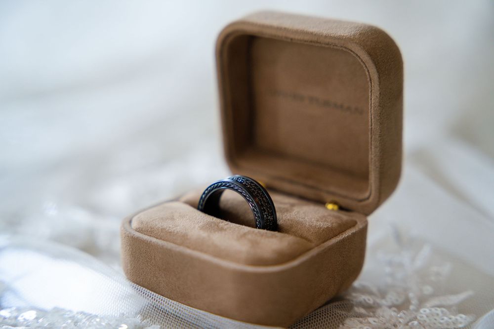 A brown leather ring box sits open on a white surface showing multiple angles and perspectives.