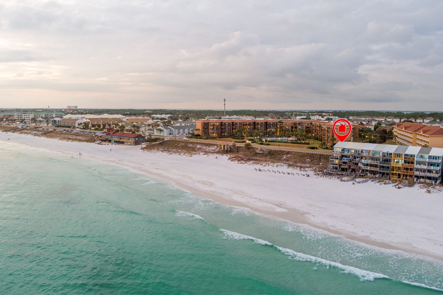 Aerial view of Panama City Beach shoreline with turquoise waters and white sand beach during sunset.