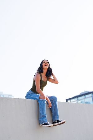 Candid rooftop portrait in casual attire with urban backdrop.